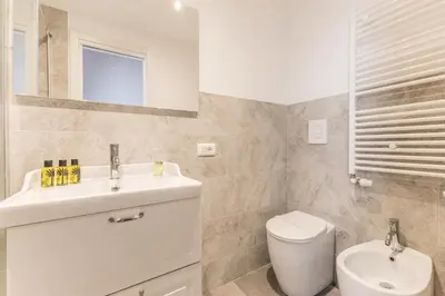a white bathroom with a sink and a toilet at APT ROME Fratte di Trastevere in Rome