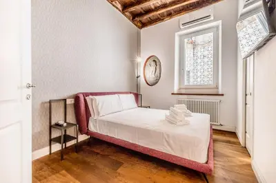 a bedroom with a bed and a clock on the wall at APT ROME Fratte di Trastevere in Rome