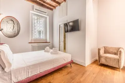 a bedroom with a bed and a chair at APT ROME Fratte di Trastevere in Rome