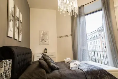 a bedroom with a bed with a chandelier and a window at Casa Mia Nazionale in Rome
