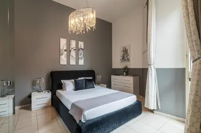 a bedroom with a large bed and a chandelier at Casa Mia Nazionale in Rome