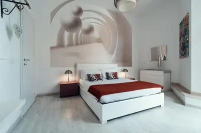a white bedroom with a bed with a red blanket at Casa Mia Nazionale in Rome