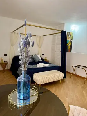 a room with a bed and a table with a vase with flowers at Casa JULIA in Rome