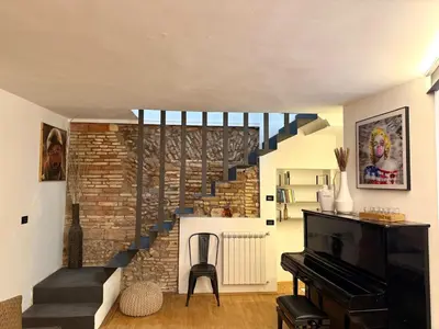 a staircase in a living room with a piano at Casa JULIA in Rome
