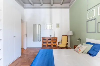 a bedroom with a large bed and a chair at Elegance near Navona-for 5 guests in Rome