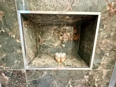 a group of three pairs of shoes in a niche in a stone wall at ETERNA Repubblica Apartment in Rome