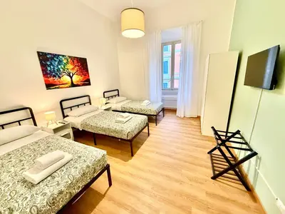a room with three beds and a flat screen tv at ETERNA Repubblica Apartment in Rome