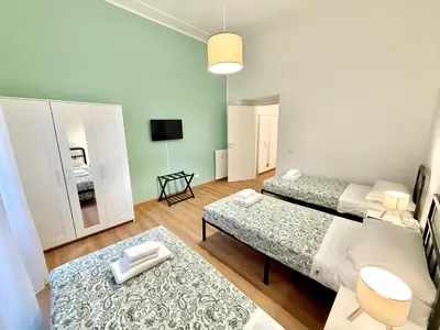 a living room with two beds and a television at ETERNA Repubblica Apartment in Rome