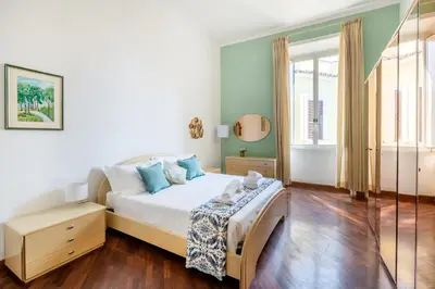 a bedroom with a bed with white sheets and blue pillows at Pigneto House - Residenze Romanae in Rome