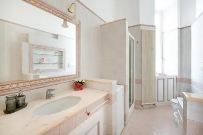 a white bathroom with a sink and a mirror at Pigneto House - Residenze Romanae in Rome