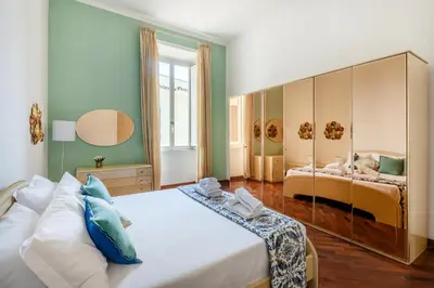 a bedroom with a large white bed and a mirror at Pigneto House - Residenze Romanae in Rome