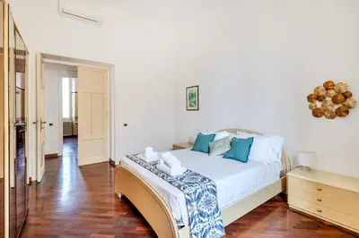 a bedroom with a white bed with blue pillows at Pigneto House - Residenze Romanae in Rome