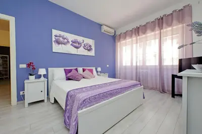 a purple bedroom with a bed and a purple wall at Victoria Apartment in Rome