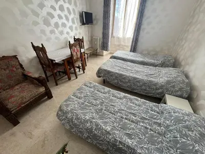 a room with three beds and a table and chairs at B&B Kevin's Home in Rome