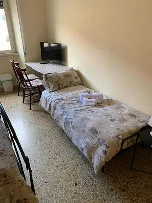 a bedroom with two beds and a table and a chair at Da Giulia in Rome