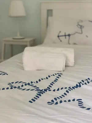 a white bed with blue decorations on it at Da Giulia in Rome