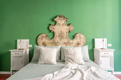 a bedroom with a large bed with green walls at Top Location - walk to Navona Pantheon and Vatican in Rome