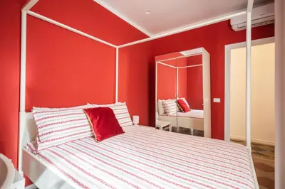 a bedroom with a white bed with a red wall at Top Location - walk to Navona Pantheon and Vatican in Rome