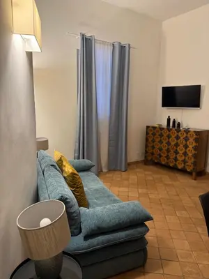 a living room with a blue couch and a television at Apartment AppiaAntica in Rome