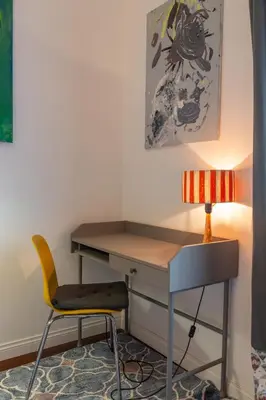 a desk with a chair and a lamp at Suite Elizabeth in Barberini in Rome