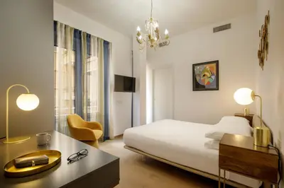 a hotel room with a bed and a desk and chair at Santaluna in Rome