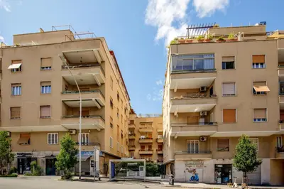 a tall apartment building with windows on a street at Santaluna in Rome