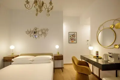 a bedroom with a bed and a vanity and a mirror at Santaluna in Rome