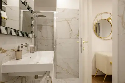 a white bathroom with a sink and a mirror at Santaluna in Rome