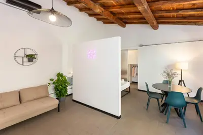 a living room with a couch and a table and chairs at Loft Ostiense Blue in Rome