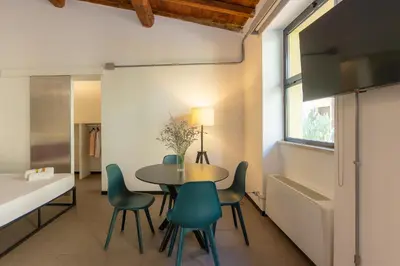 a dining room with a table and chairs and a window at Loft Ostiense Blue in Rome