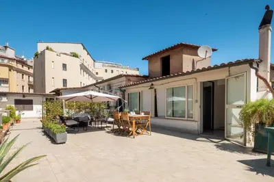 a patio with a table and chairs and an umbrella at Laura Roof Terrace Teatro dell'Opera in Rome