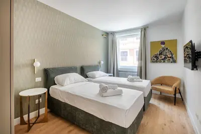 a hotel room with two beds and a chair at 3 bedroom superior apartment Trastevere in Rome