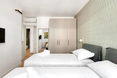 two beds in a room with white walls at 3 bedroom superior apartment Trastevere in Rome