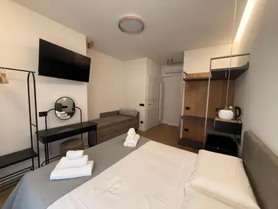 a bedroom with a white bed and a couch at Ulivo Guest House Roma in Rome