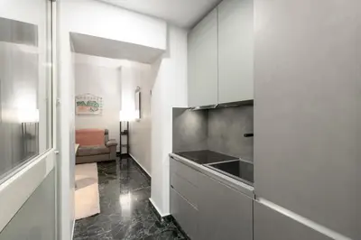 a kitchen with white cabinets and a sink at DOMUS Generale Ezio in Rome