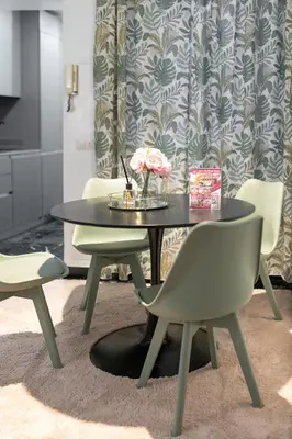 a black table with chairs and a vase of flowers on it at DOMUS Generale Ezio in Rome