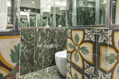a bathroom with a toilet and mosaics on the wall at DOMUS Generale Ezio in Rome
