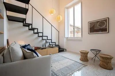 a living room with a couch and a staircase at TreasureRome Forum Terrace in Rome