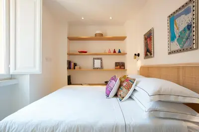 a bedroom with a white bed with pillows on it at TreasureRome Forum Terrace in Rome