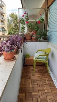 a balcony with potted plants and a yellow chair at casawally MetroB Marconi SanPaoloBasilica Colosseo in Rome