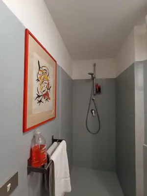 a bathroom with a shower and a painting on the wall at casaemily TrenoFiumicinoAir-VillaBonelli-Ostiense in Rome