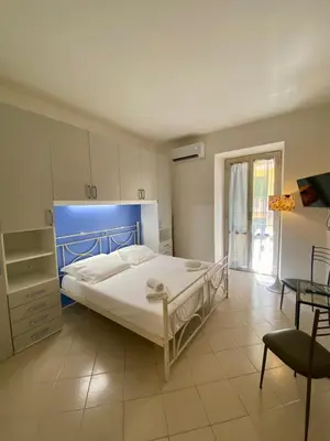 a bedroom with a large bed with a blue headboard at Coral Apartment in Rome