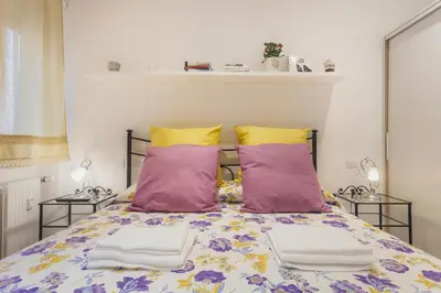 a bed with purple and yellow pillows in a room at Le Scalette Al Vaticano B&B in Rome