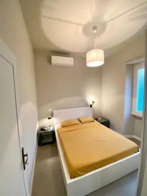 a bedroom with a bed with yellow sheets and a window at Balduina Boutique Apartment in Rome