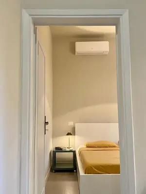 a small bedroom with a bed and a bedside table at Balduina Boutique Apartment in Rome