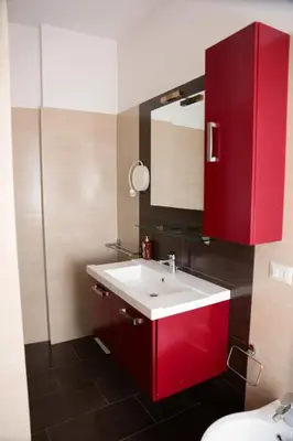 a bathroom with a red cabinet and a sink at Nice flat near Trastevere Station in Rome