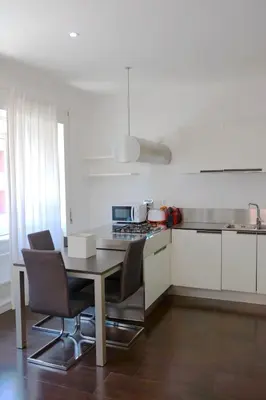 a kitchen with a table and chairs in a kitchen at Nice flat near Trastevere Station in Rome