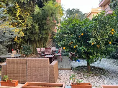 a garden with an orange tree and a table and chairs at Villa Sciarra BnB in Rome