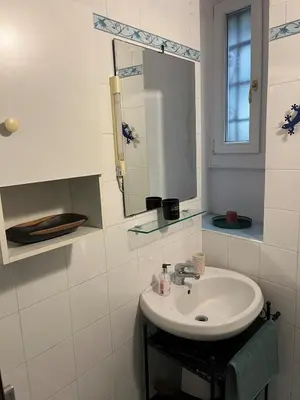 a white bathroom with a sink and a mirror at Villa Sciarra BnB in Rome