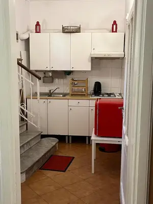 a kitchen with white cabinets and a red stove at Villa Sciarra BnB in Rome